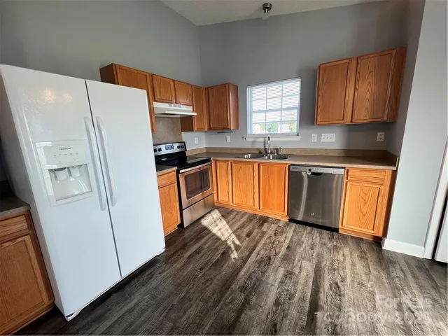 a kitchen with granite countertop stainless steel appliances a refrigerator microwave and sink