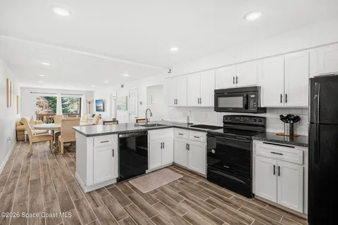 a kitchen with kitchen island a dining table chairs and a refrigerator