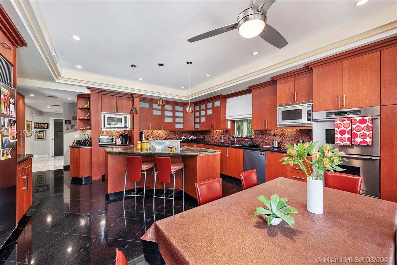 2995 Flamingo Drive Miami Beach, FL 33140 - Photo 32 of 54 a kitchen with stainless steel appliances wooden floor dining table and chairs
