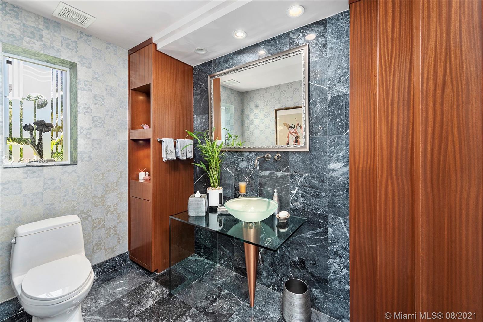 2995 Flamingo Drive Miami Beach, FL 33140 - Photo 36 of 54 a bathroom with a toilet a sink and mirror