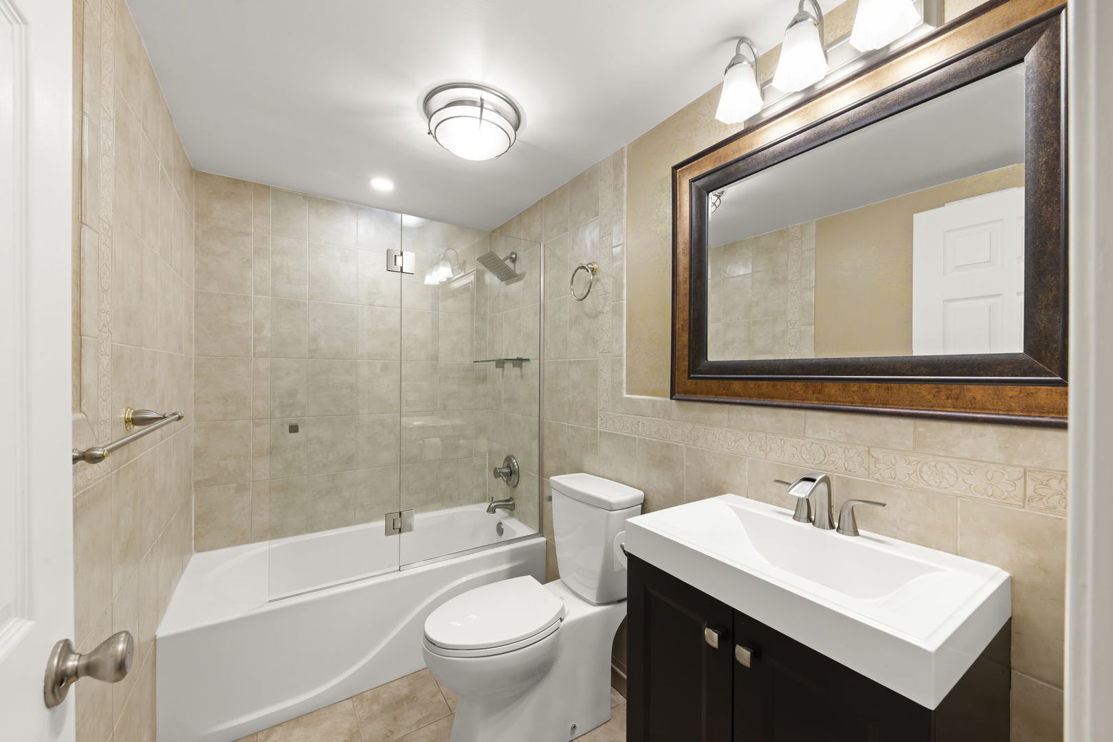 1338 South Lorraine Road, Unit D Wheaton, IL 60189 - Photo 14 of 23 a bathroom with a bathtub shower sink mirror vanity and toilet