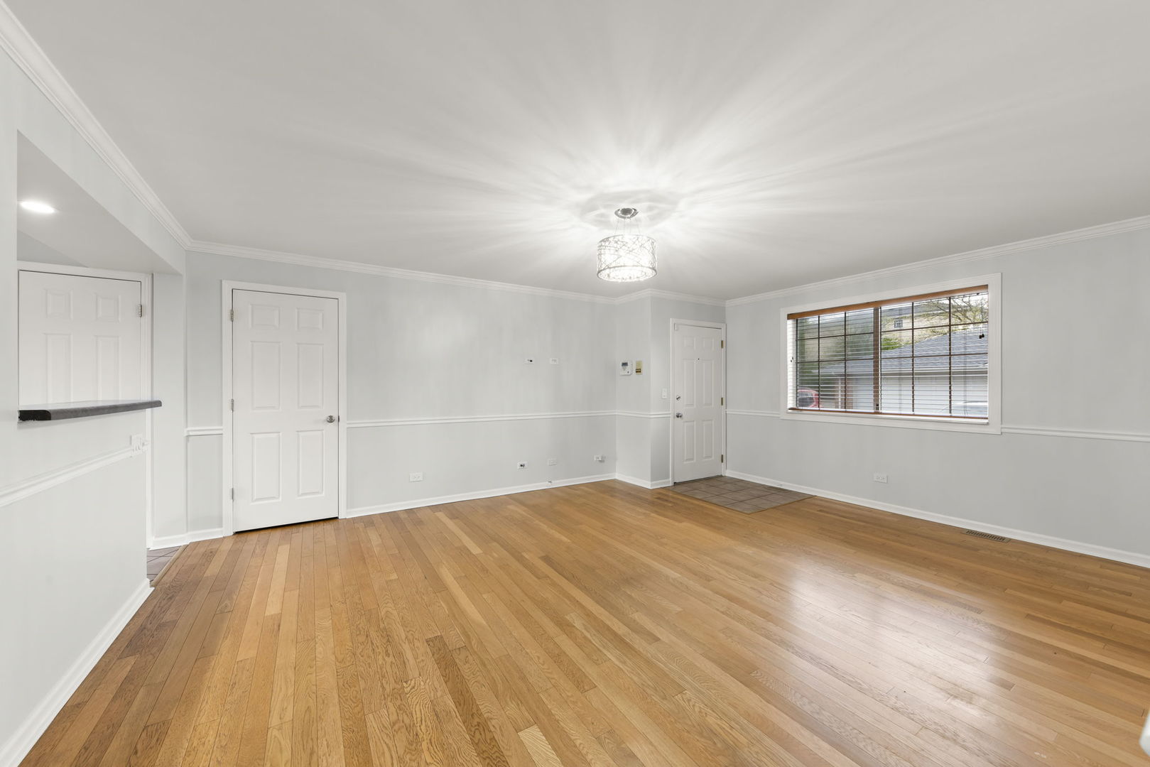 1338 South Lorraine Road, Unit D Wheaton, IL 60189 - Photo 4 of 23 a view of an empty room with wooden floor and a window