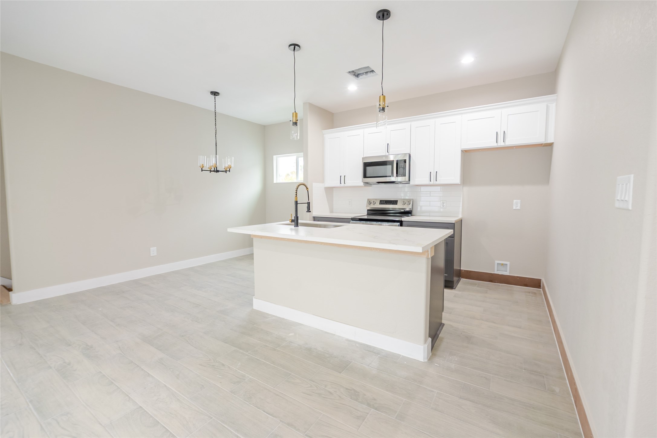 8707 Westcott Road, Unit A AND B Houston, TX 77016 - Photo 4 of 14 a kitchen with kitchen island a sink stainless steel appliances and white cabinets