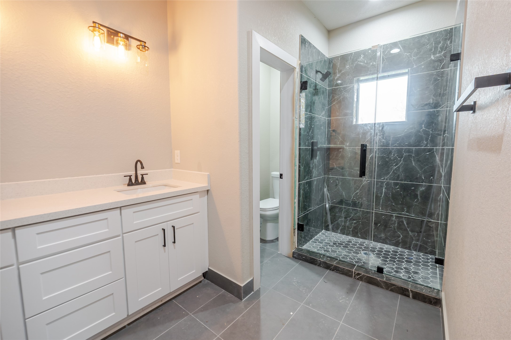 8707 Westcott Road, Unit A AND B Houston, TX 77016 - Photo 8 of 14 a bathroom with a granite countertop sink a mirror and a shower