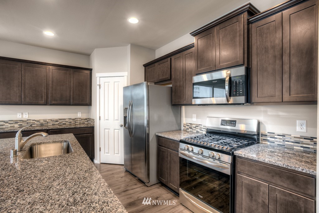 21127 Meridian Drive Southeast, Unit P23 Bothell, WA 98021 - Photo 3 of 40 a kitchen with granite countertop stainless steel appliances cabinets a sink and a counter top space