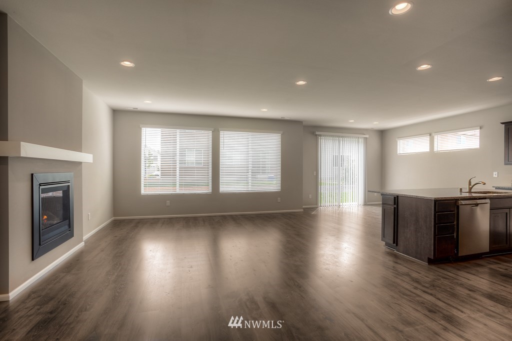 21127 Meridian Drive Southeast, Unit P23 Bothell, WA 98021 - Photo 32 of 40 an empty room with wooden floor fireplace and windows