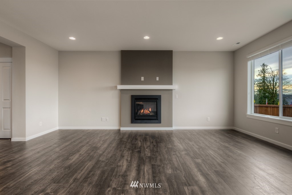 21127 Meridian Drive Southeast, Unit P23 Bothell, WA 98021 - Photo 9 of 40 a view of an empty room with wooden floor fireplace and a window