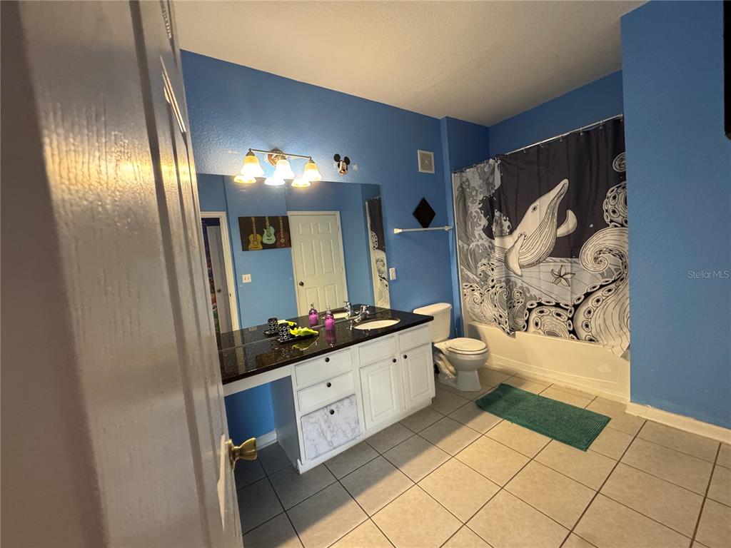 7664 Comrow Street, Unit 204 Kissimmee, FL 34747 - Photo 11 of 17 a spacious bathroom with a double vanity sink toilet mirror and bathtub