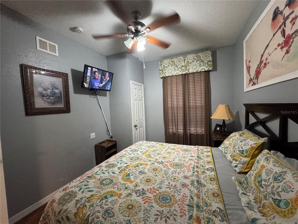 7664 Comrow Street, Unit 204 Kissimmee, FL 34747 - Photo 12 of 17 a bedroom with a bed and a chandelier
