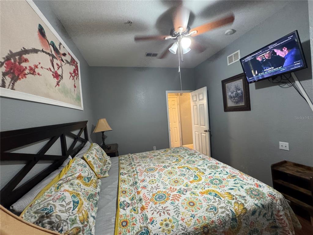 7664 Comrow Street, Unit 204 Kissimmee, FL 34747 - Photo 13 of 17 a bedroom with a bed and a chandelier