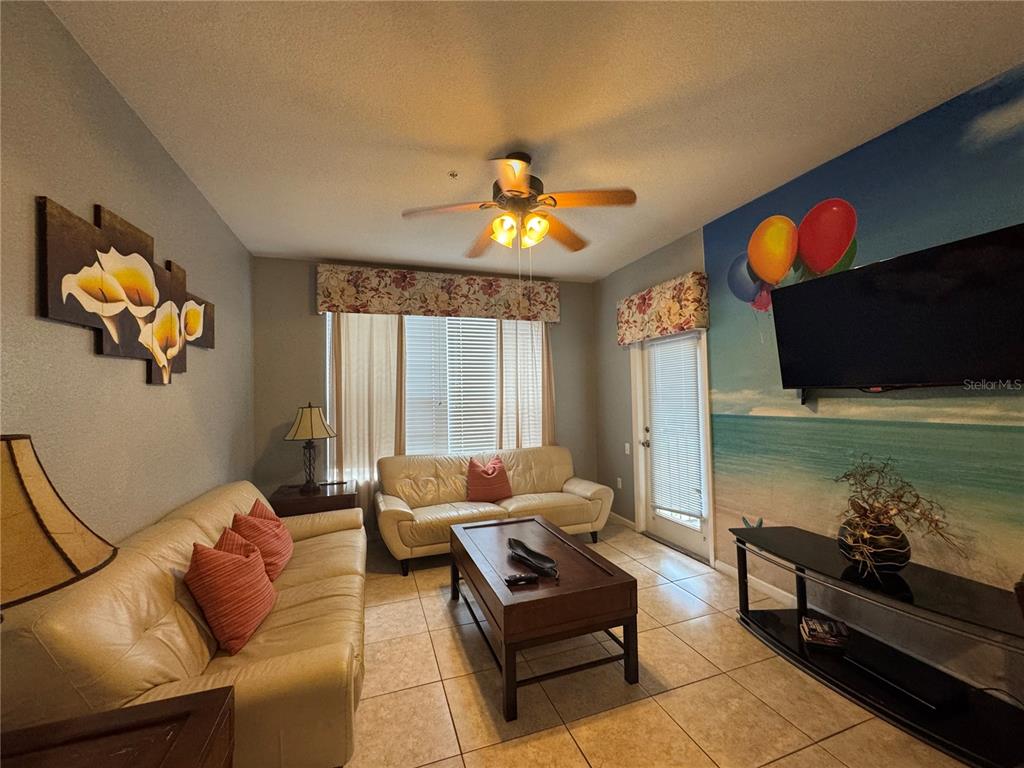 7664 Comrow Street, Unit 204 Kissimmee, FL 34747 - Photo 4 of 17 a living room with furniture a rug and a chandelier