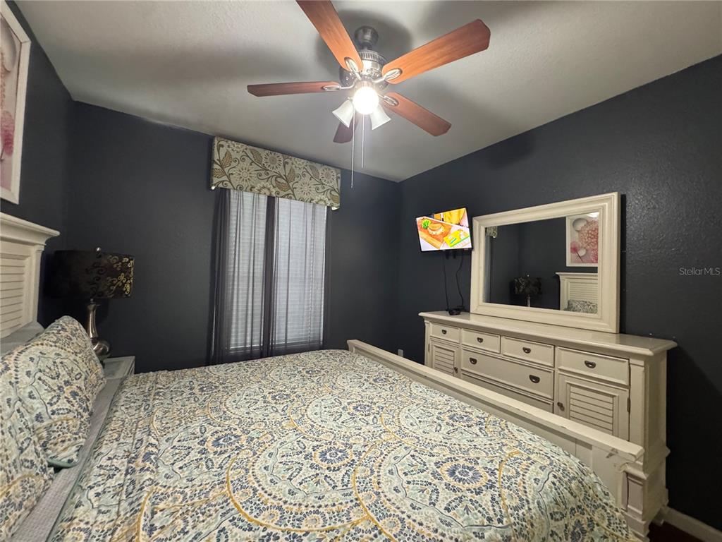 7664 Comrow Street, Unit 204 Kissimmee, FL 34747 - Photo 6 of 17 a bedroom with a bed and a chandelier