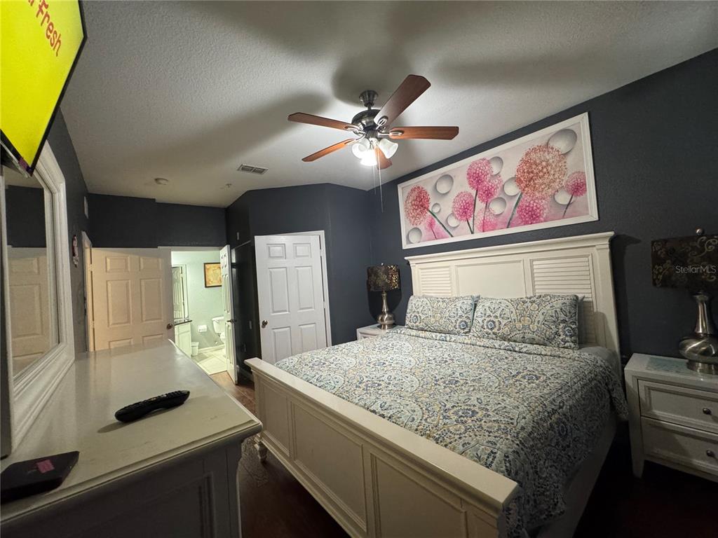 7664 Comrow Street, Unit 204 Kissimmee, FL 34747 - Photo 8 of 17 a bedroom with a large bed and a flat tv screen on dresser