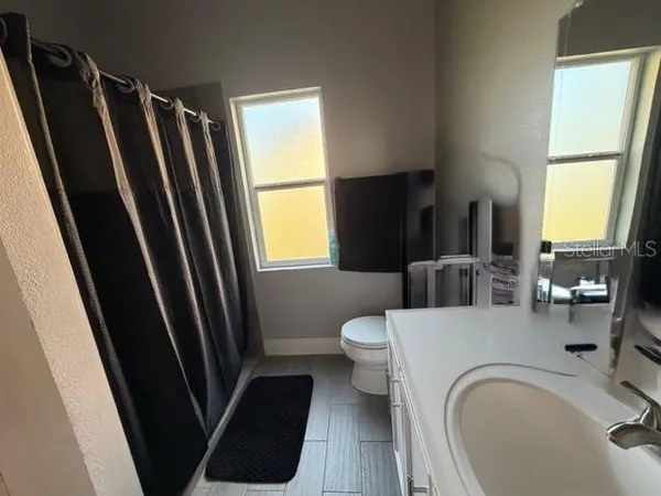 a bathroom with a sink a toilet and a mirror