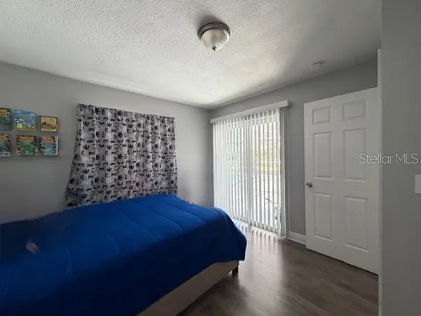 a bed sitting in a spacious bedroom next to a window