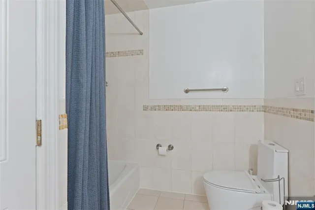 a bathroom with a granite countertop toilet and a sink