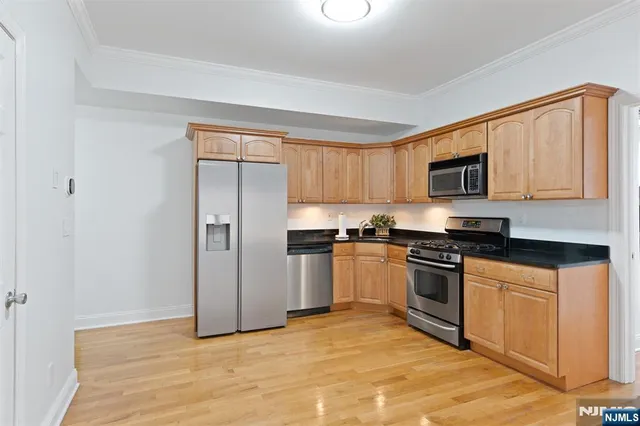 a kitchen with granite countertop a refrigerator and a stove top oven