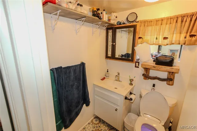 a bathroom with a sink mirror vanity and toilet