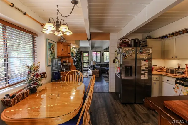 a dining room with furniture a chandelier and wooden floor