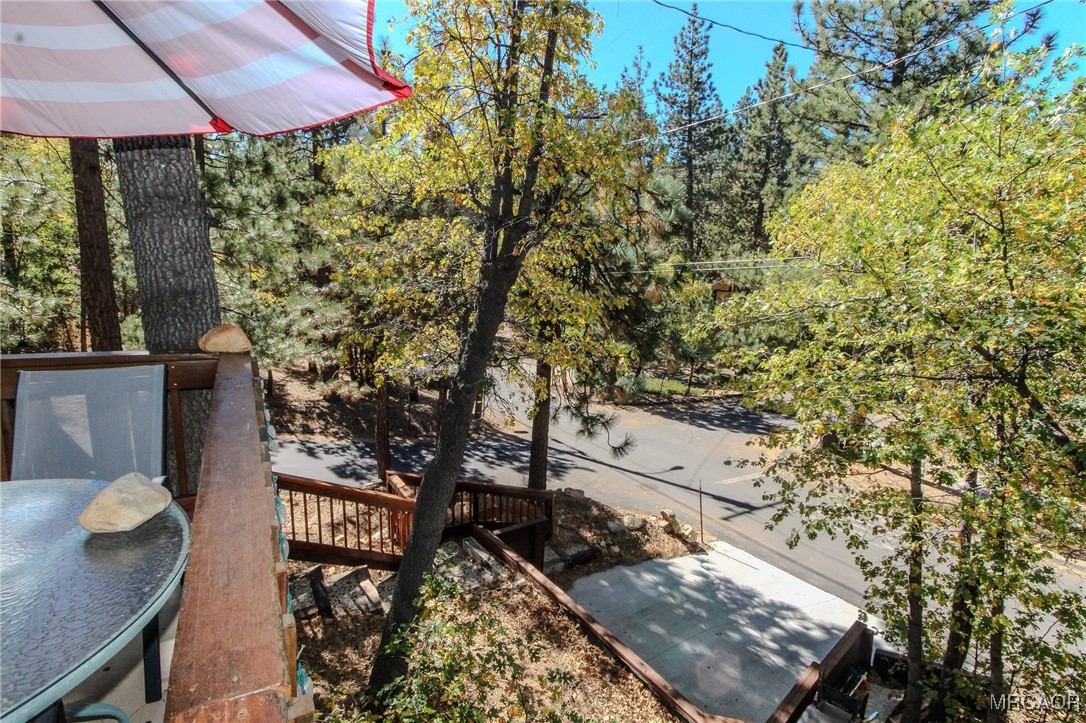 699 Santa Barbara Avenue Sugarloaf, CA 92386 - Photo 32 of 35 a balcony with table and chairs and wooden fence