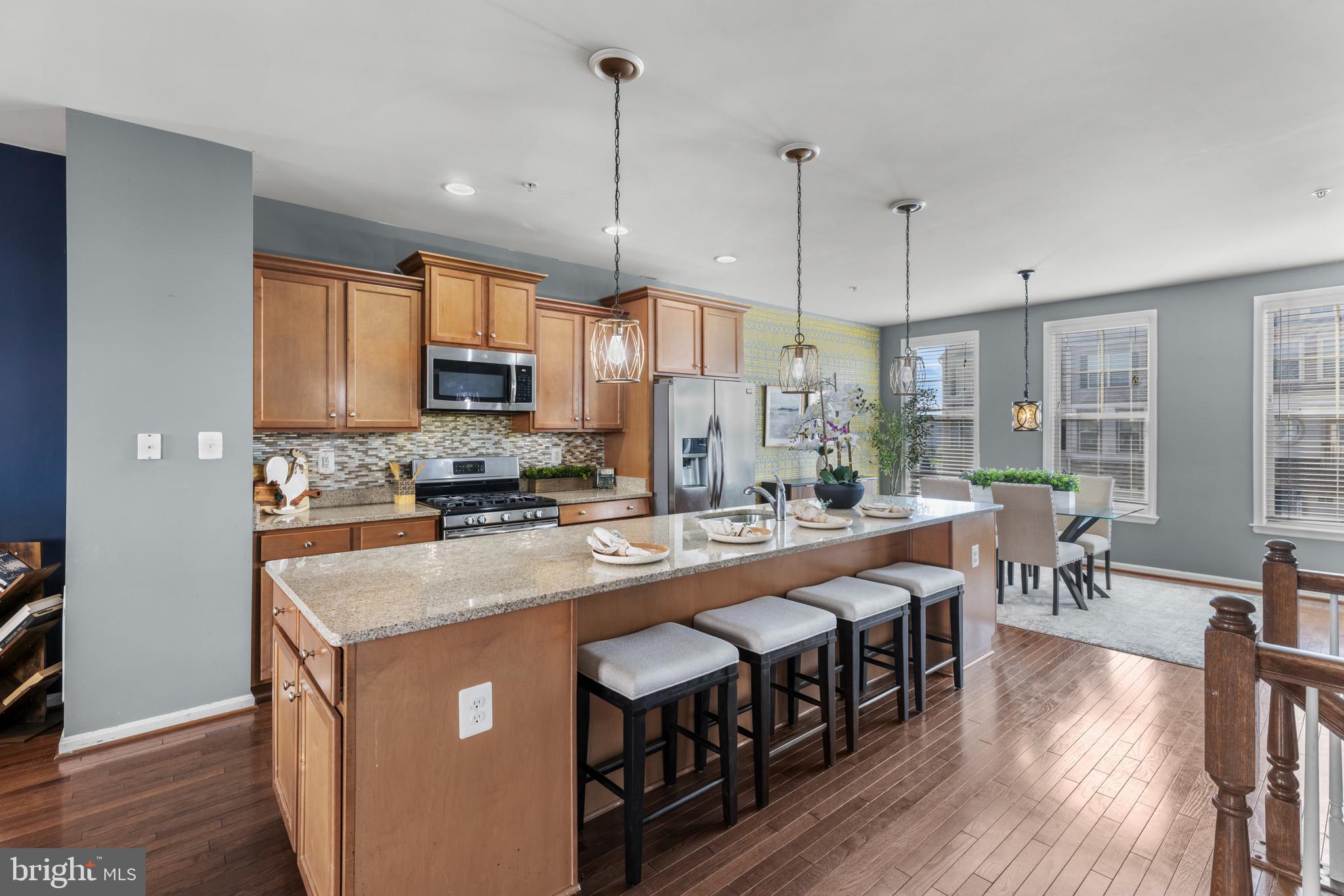 6552 Britannic Place Frederick, MD 21703 - Photo 7 of 34 a large kitchen with stainless steel appliances granite countertop a stove and a wooden floors