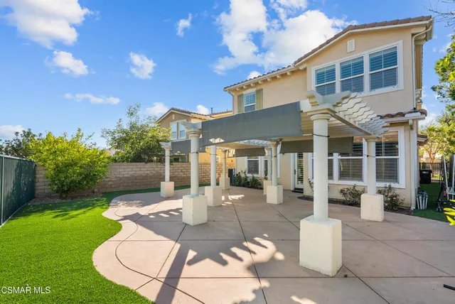 a front view of a house with a yard and potted plants