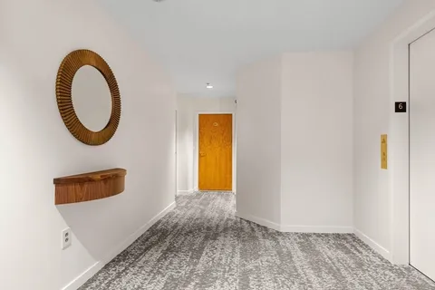 a view of a room that has a bed and a dresser in it