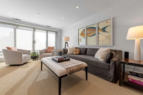 a living room with furniture a lamp and a table
