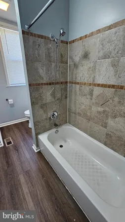 a bathroom with a tub a sink and mirror