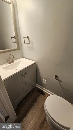 a bathroom with a granite countertop toilet and a sink