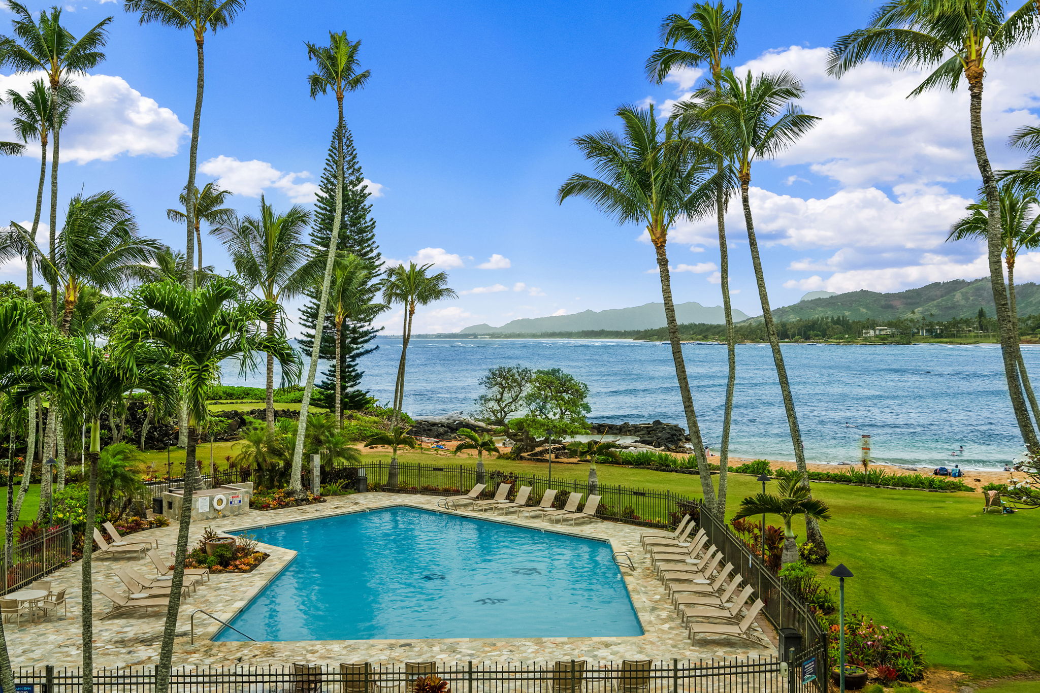 410 Papaloa Road, Unit 233 Kapaa, HI 96746 - Photo 1 of 27 a view of a swimming pool with a table and chairs