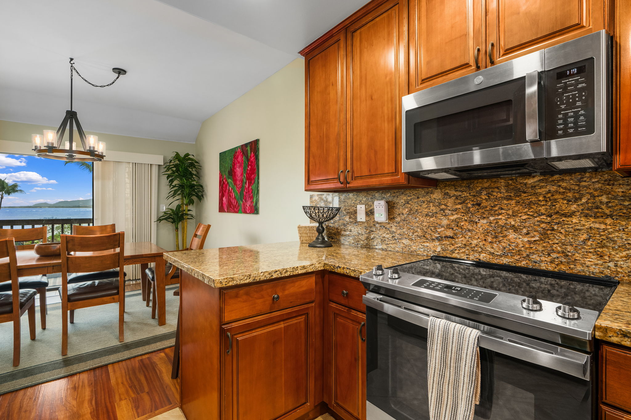 410 Papaloa Road, Unit 233 Kapaa, HI 96746 - Photo 7 of 27 a kitchen with stainless steel appliances granite countertop a stove top oven microwave and cabinets