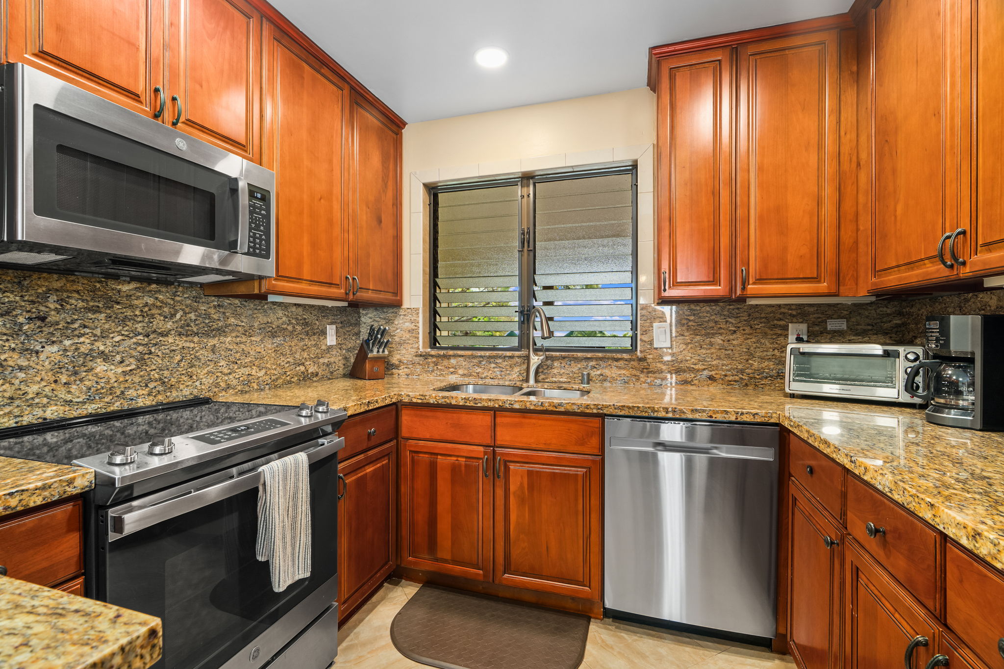 410 Papaloa Road, Unit 233 Kapaa, HI 96746 - Photo 9 of 27 a kitchen with stainless steel appliances granite countertop a sink stove and microwave
