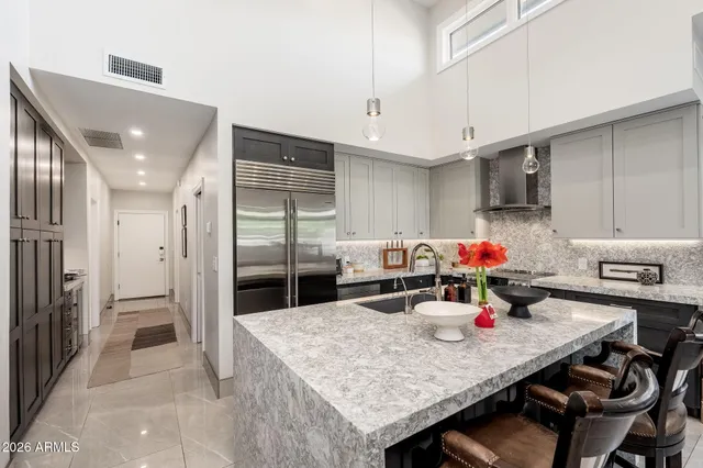 a kitchen with stainless steel appliances granite countertop a sink dishwasher and refrigerator with wooden cabinets