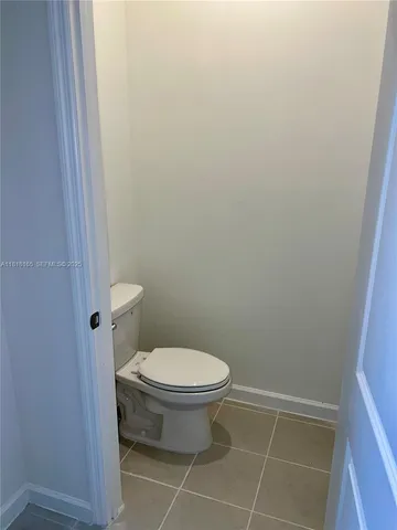 a white toilet sitting next to a shower
