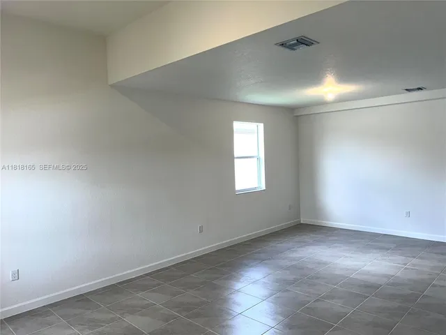 an empty room with a empty space and windows