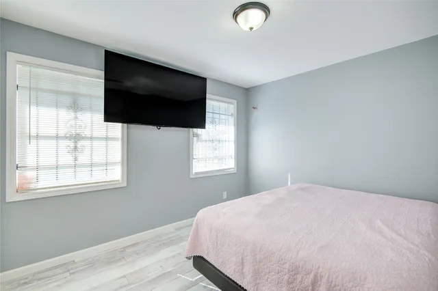 a bedroom with a flat screen tv and a window