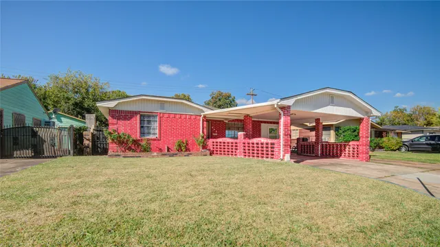 a front view of a house with large trees and a big yard