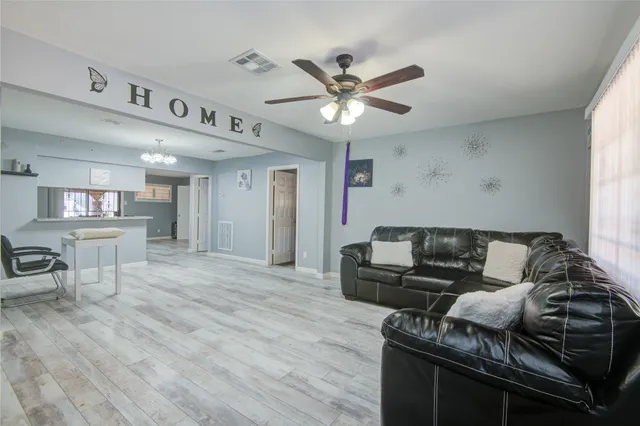 a living room with furniture and a wooden floor