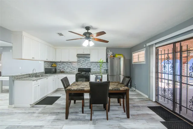 a kitchen with stainless steel appliances granite countertop a stove a sink dishwasher and a refrigerator with wooden floor