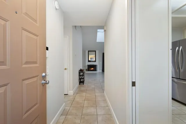 a view of a hallway with closet and a bathroom