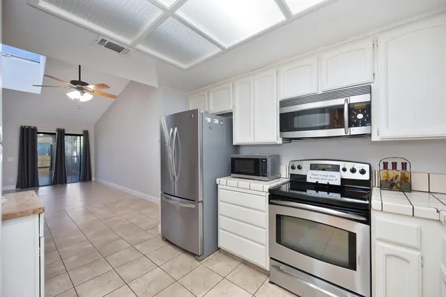 a kitchen with cabinets stainless steel appliances and a counter space
