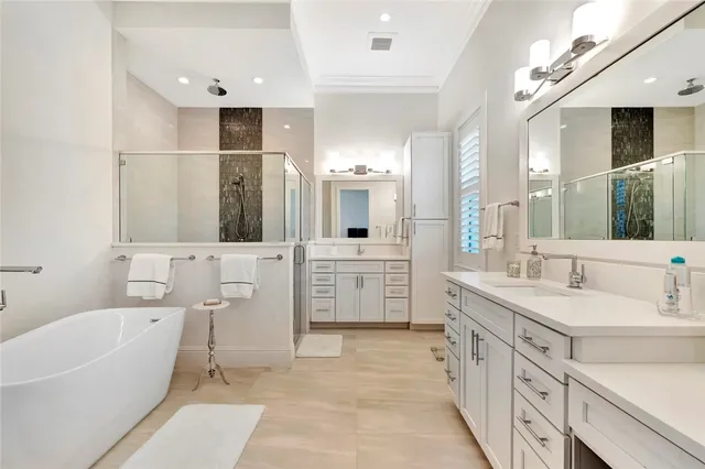 a bathroom with a double vanity sink mirror and bathtub