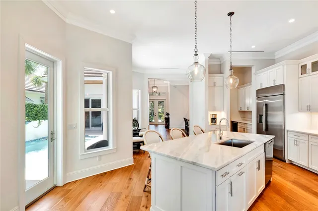 a kitchen with stainless steel appliances kitchen island granite countertop a sink a counter space and a window
