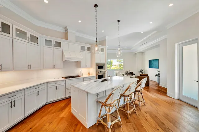 a kitchen with stainless steel appliances granite countertop a kitchen island a stove a table and chairs in it