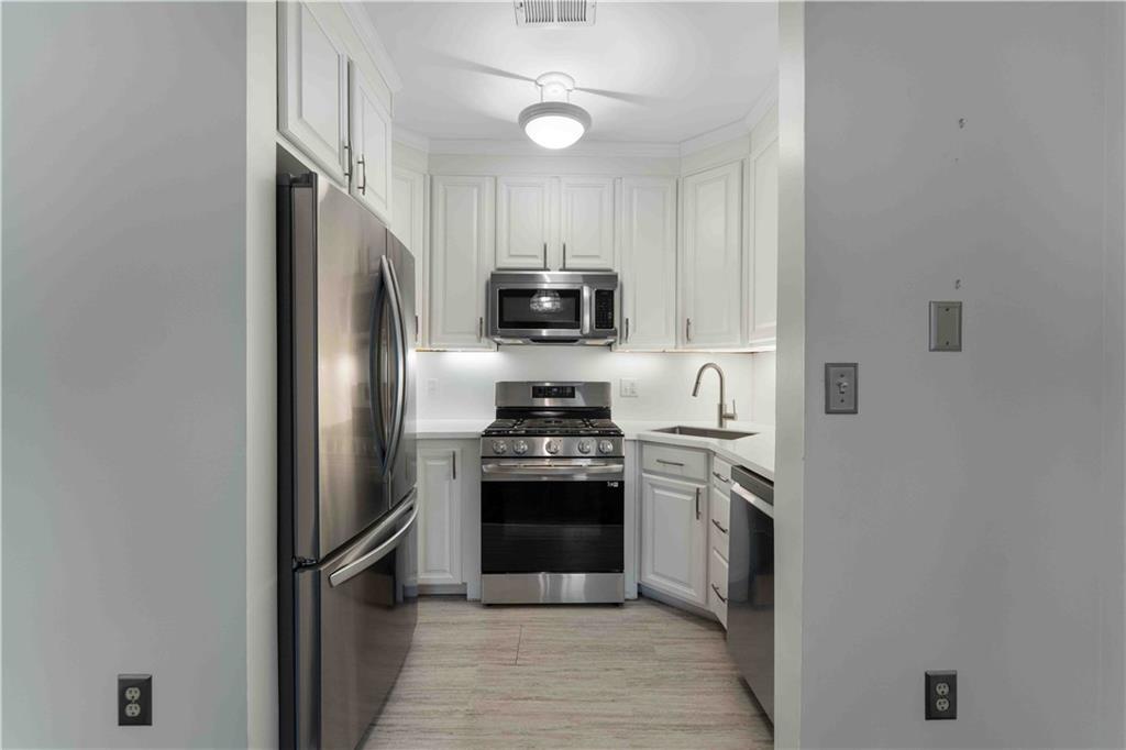 363 4th Street, Unit 6 Beaver, PA 15009 - Photo 15 of 34 The remodeled kitchen features crisp tones, new cabinetry, modern countertops, and stainless steel appliances in a smart, galley-style layout.