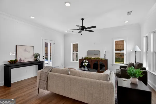 a living room with furniture and a wooden floor