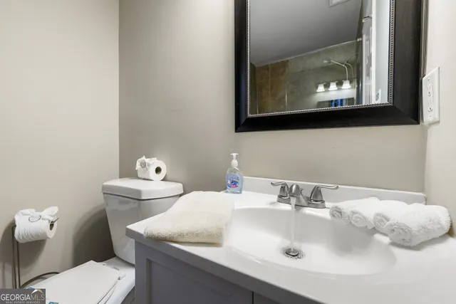 a bathroom with a toilet sink and mirror