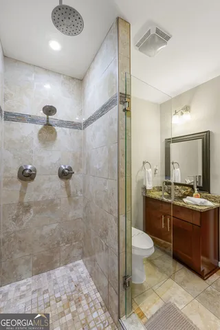a bathroom with a double vanity sink toilet and shower