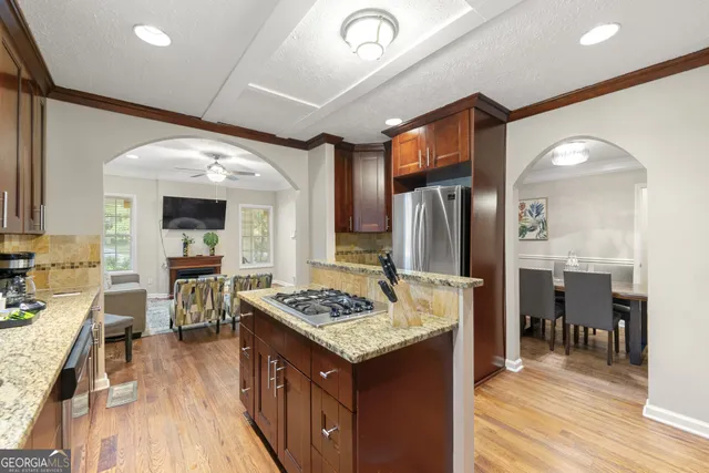 a kitchen with stainless steel appliances granite countertop a stove refrigerator and cabinets